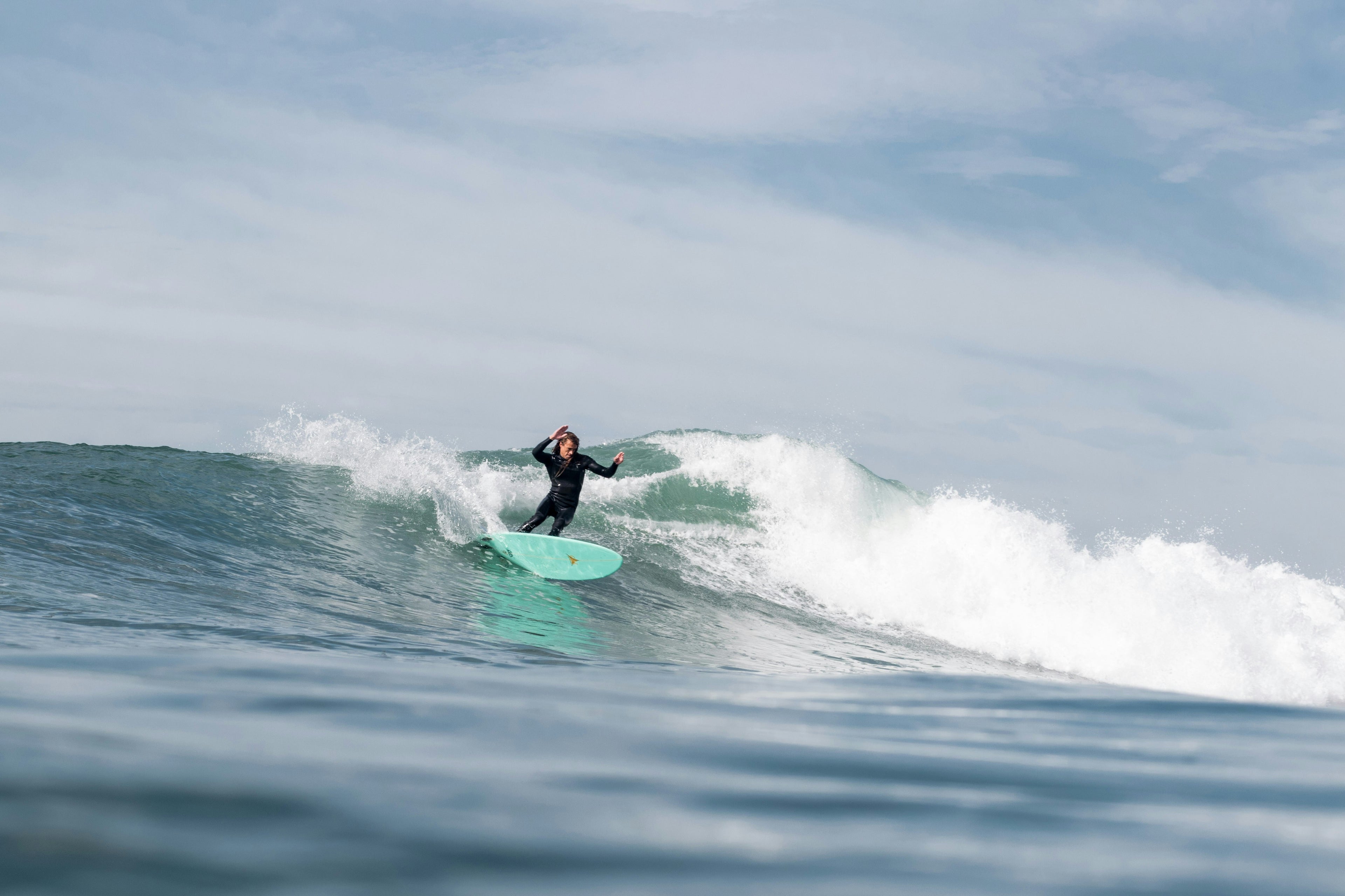 Person surfing on a wave with a clear sky